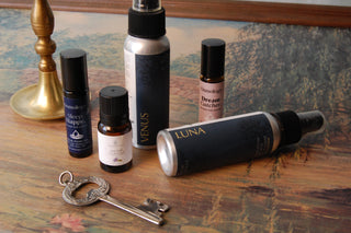 Collection of pillow and linen sprays, pulse point oils and essential oils photographed next to a decorative key.