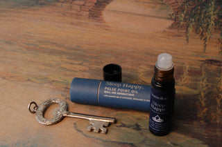 Sleep Happy Pulse Point Oil shown with packaging and a key over a painted background.