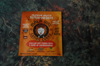 Mala Girl Cosmic Curry packet shown against a painting.